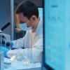 A molecular biologist working with a microscope in a modern scientific Laboratory, we see a computer screen in the foreground- CREDIT - istock-1390303303