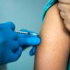 Doctor's hands vaccinating a woman stock photo CREDIT-iStock-1444188743