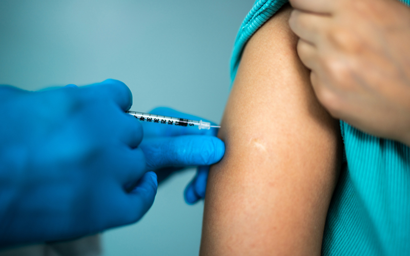 Doctor's hands vaccinating a woman stock photo CREDIT-iStock-1444188743